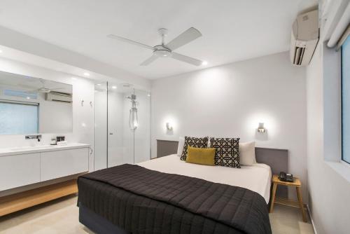 a bedroom with a bed with a ceiling fan at Mantra French Quarter Noosa in Noosa Heads