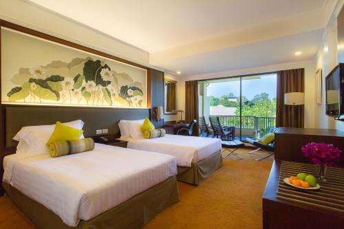 a hotel room with two beds and a balcony at Dusit Thani Pattaya in North Pattaya