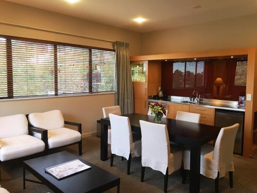 a kitchen and dining room with a table and chairs at Commodore Airport Hotel Christchurch in Christchurch