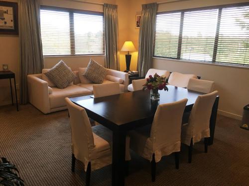a living room with a table and a couch at Commodore Airport Hotel Christchurch in Christchurch