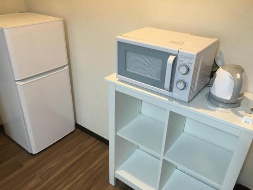 a microwave sitting on a table next to a refrigerator at TIMES INN 2F in Tokyo