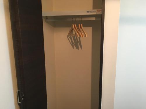 a closet with a black door and some hangers at TIMES INN 2F in Tokyo