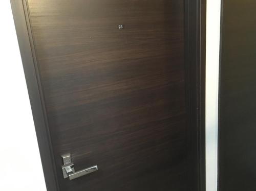 a wooden door with a handle in a room at TIMES INN 2F in Tokyo