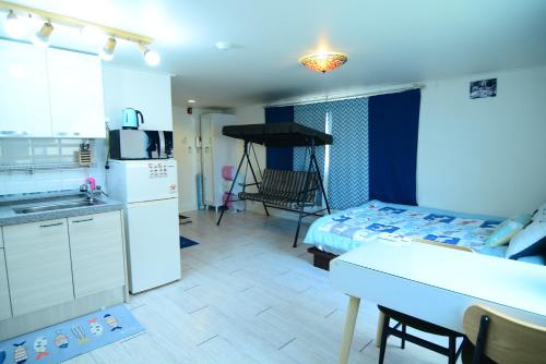 a kitchen with a table and a kitchen with a bed at Residence Unicorn in Seoul