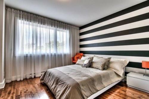 a bedroom with a large bed with a striped wall at Deguire Palace in Montreal