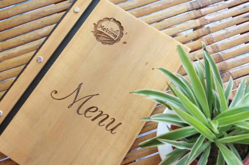 a sign that says meinn next to a plant at Mekong Rustic Cai Be in Cai Be