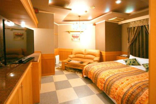 une chambre d'hôtel avec un lit, un canapé et une télévision dans l'établissement SARI Resort Kawanishi (Adult Only), à Kawanishi