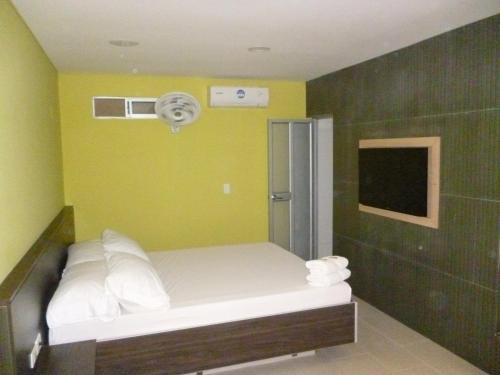 a small room with a bed with a fan at Hotel 56 Avenue Plaza in Barranquilla