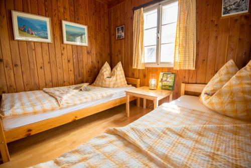 a bedroom with two beds in a wooden room at Walcherhof in Arriach