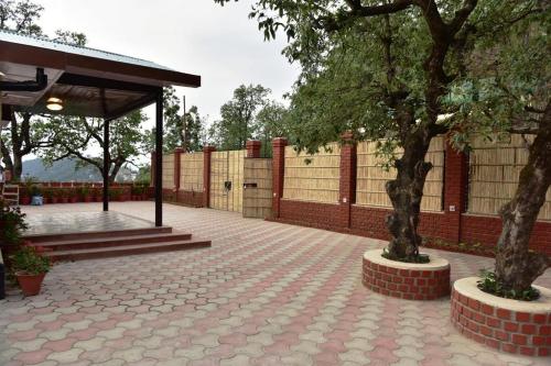a pavilion with two trees in a courtyard at The Oaktree House in Shimla