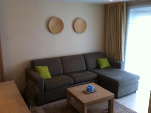 un soggiorno con divano e tavolo di appartement in nieuwpoort a Nieuwpoort