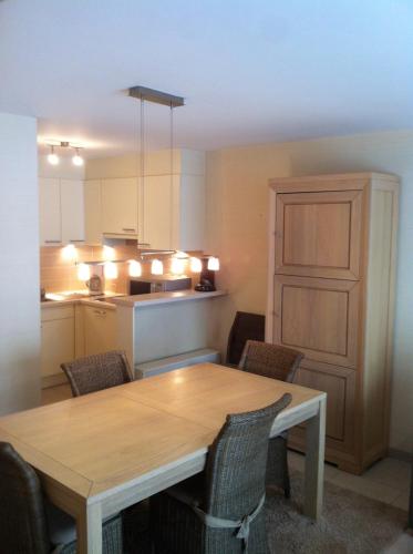 een eettafel met stoelen en een keuken bij appartement in nieuwpoort in Nieuwpoort
