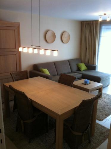 un soggiorno con tavolo e divano di appartement in nieuwpoort a Nieuwpoort