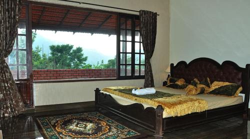 a bedroom with a large bed with a large window at Abiyal Mountain Stay in Madikeri