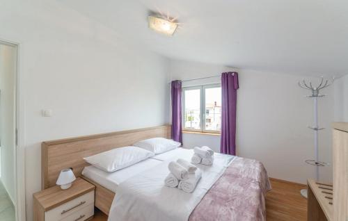 a bedroom with a bed with two towels on it at Apartments Magdalena in Maslenica