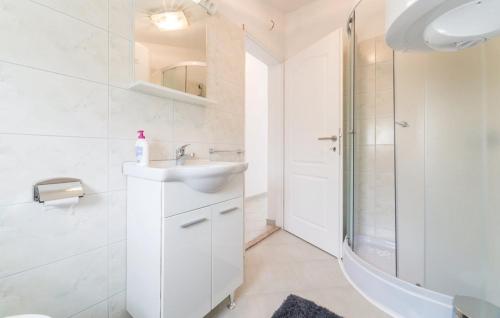 a white bathroom with a sink and a shower at Apartments Magdalena in Maslenica