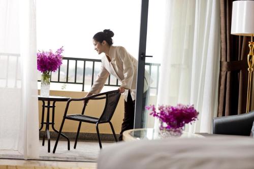 a woman standing next to a chair in a room at Your World International Conference Centre Hotel in Yiwu