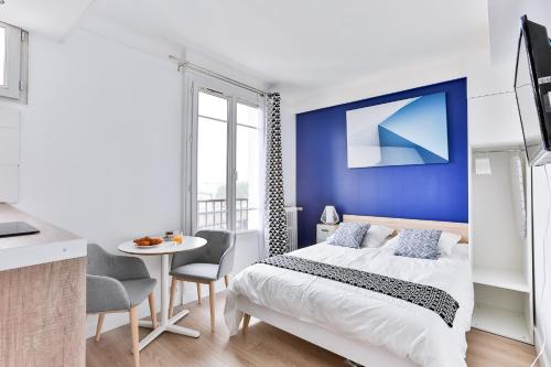 ヌイイ・プレザンスにあるStudio Edgar Quinetの青い壁のベッドルーム1室(ベッド1台付)
