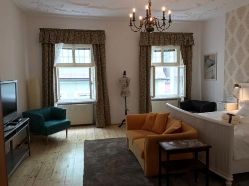 a bedroom with a bed and a couch and a tv at Lovely Flat in a Lovely City in Steyr