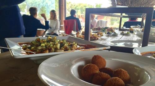 a table with a bowl of food and a plate of food at Vallegrande Nature Resort by Geocharme in Cefalù