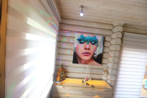 a wall with a picture of a woman in a house at Sosnowe Domki in Rewal