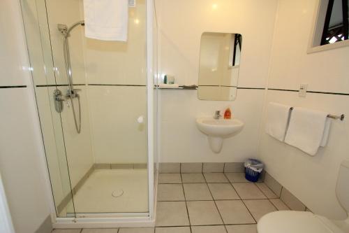 W łazience znajduje się prysznic, toaleta i umywalka. w obiekcie Walton Park Motor Lodge w mieście Warkworth