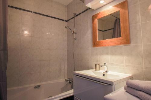 y baño con lavabo, bañera y espejo. en Castellane by Cocoonr, en Toulouse
