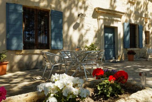 a group of chairs and flowers in front of a building at Le Mas d'Isnard in Arles