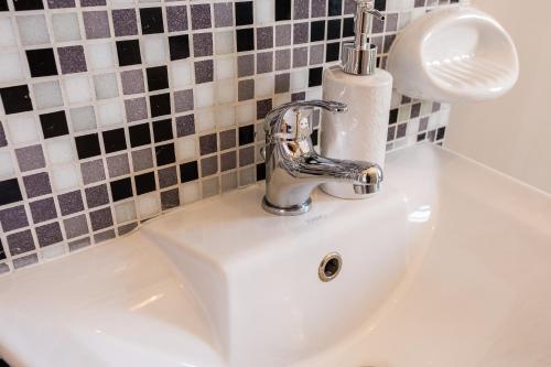 a bathroom sink with a faucet on top of it at Seaview Luxury Penthouse with Shared Swimming Pool in Għajnsielem