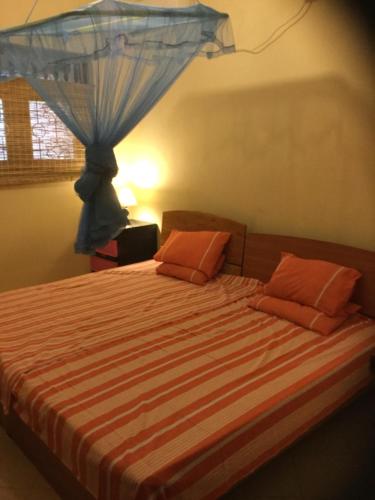 a bedroom with a bed with orange pillows at Galappathie Residence in Tangalle