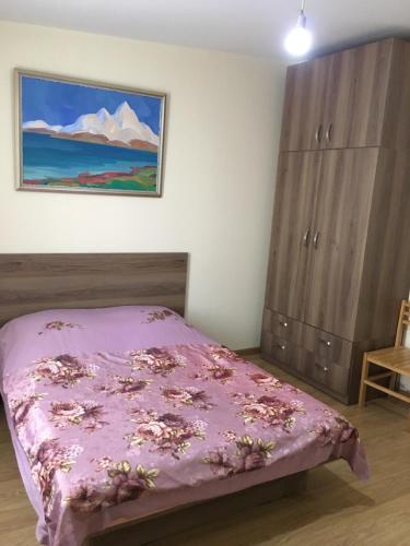 a bedroom with a pink bed and a painting on the wall at Art Guesthouse in Yerevan