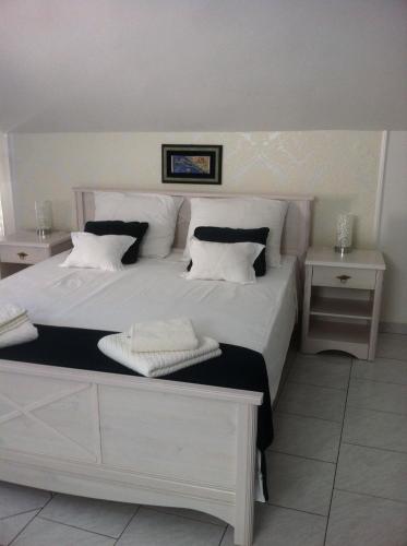 a bedroom with a large white bed with two tables at Apartment Josip in Korčula