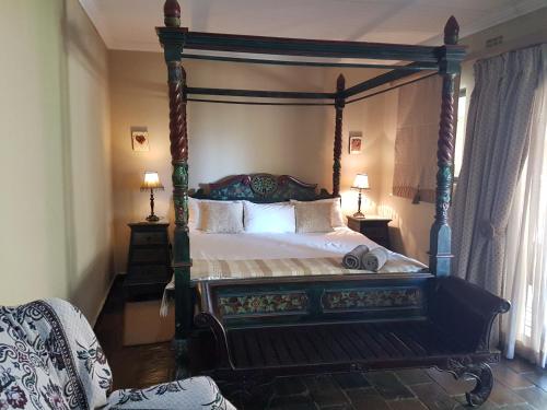 a bedroom with a canopy bed and two lamps at Santai guesthouse in Brits