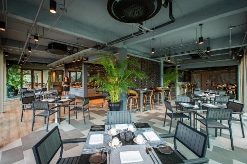 a restaurant with tables and chairs and people in the background at Fusion Suites Phuket Patong in Patong Beach