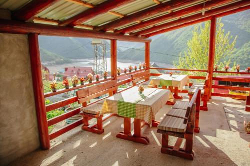 a table and benches on a balcony with a view at Guesthouse Madzarevic in Pluzine