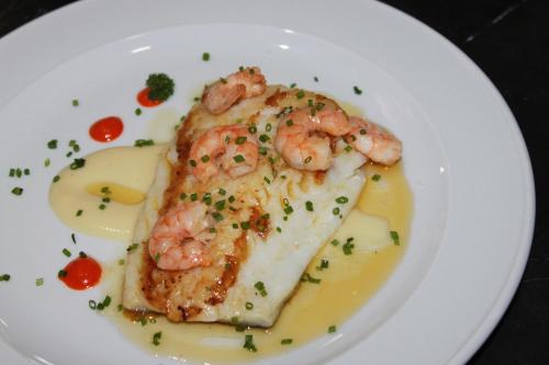 a white plate with a piece of food with shrimp on it at Hotel Restaurante Santa Cruz in Santa Cruz de Mudela
