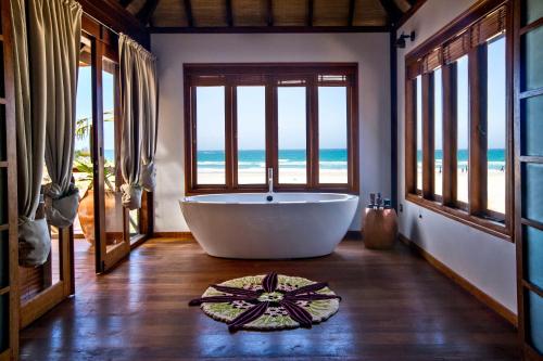 MiramarにあるSentidos Beach Retreatの海の景色を望む客室で、バスタブが備わります。