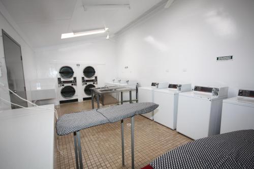a laundry room with washing machines and a table at Discovery Parks - Alice Springs in Alice Springs