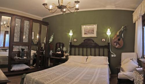 a bedroom with a large bed and a chandelier at Apartamentos Sabor Rural I in León