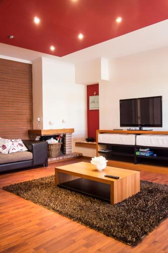 a living room with a couch and a tv at Deluxe Apart in Furadouro