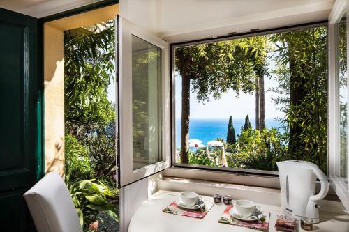 a room with a window with a view of the ocean at Hotel Villa Belvedere in Taormina