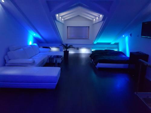 a living room with a couch and blue lights at Jacuzzi Penthouse Apartment in Matulji