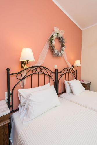 two beds in a bedroom with orange walls at Lorenzo Villas with Private Pool, 200m from the beach, by ZanteWize in Lithakia