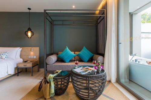 a room with a bed and a couch and a tub at Fusion Suites Phuket Patong in Patong Beach