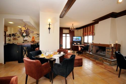 een woonkamer met een tafel en stoelen en een open haard bij Guesthouse Kapaniaris in Zagora