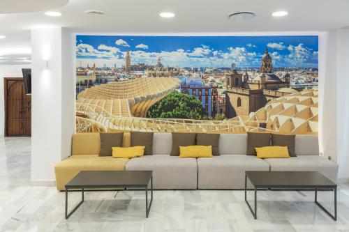 a living room with a couch and a painting of a city at Bellavista Sevilla in Seville