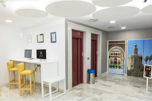 a room with a desk and chairs and a red door at Bellavista Sevilla in Seville
