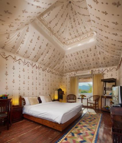 a bedroom with a bed and a coffered ceiling at Aaram Baagh Pushkar by Pachar Group in Pushkar