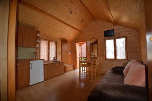 a kitchen and living room of a log cabin at DorJan - Domki Letniskowe in Dziwnówek