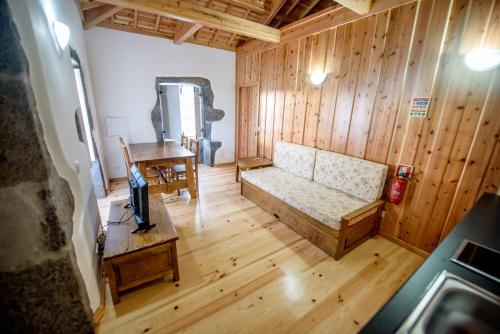 ein Wohnzimmer mit einem Sofa und einem Tisch in der Unterkunft Casa Branca do Imperio in Cinco Ribeiras